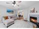 Cozy living room features a fireplace, plush seating, hardwood floors and natural light from the nearby windows at 1047 Woodsong Pass Ct, Lawrenceville, GA 30043