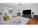 Comfortable living room features a fireplace, large screen TV, neutral colors, hardwood floors and access to the backyard at 1047 Woodsong Pass Ct, Lawrenceville, GA 30043