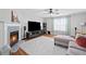 Cozy living room features a fireplace, plush seating, hardwood floors and natural light from the nearby windows at 1047 Woodsong Pass Ct, Lawrenceville, GA 30043