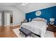 Large main bedroom with a blue accent wall, a king bed, and access to an ensuite bathroom at 1047 Woodsong Pass Ct, Lawrenceville, GA 30043