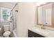 Bright bathroom featuring a modern vanity, speckled countertop, and shower with marble-like tiles at 3308 Quail Run Sw Sw Run, Marietta, GA 30008
