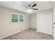 Neutral bedroom featuring a ceiling fan, a large window, and a closet with louvered doors at 3308 Quail Run Sw Sw Run, Marietta, GA 30008
