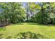 Large backyard featuring mature trees and green lawn at 4065 Old Austell Rd, Powder Springs, GA 30127