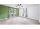 Spacious bedroom with green accent wall, neutral carpet, ceiling fan, and natural light from the windows at 4065 Old Austell Rd, Powder Springs, GA 30127