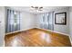 Bright bedroom with hardwood floors, ceiling fan, two windows, and blue curtains at 4065 Old Austell Rd, Powder Springs, GA 30127