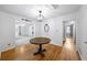 Bright dining area with hardwood floors and modern light fixture open to the living room and hallways at 4065 Old Austell Rd, Powder Springs, GA 30127