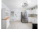 Clean kitchen featuring modern stainless appliances, white cabinets, and hardwood-style tile flooring at 4065 Old Austell Rd, Powder Springs, GA 30127