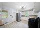 Bright kitchen featuring stainless steel appliances, white cabinetry, and tile flooring at 4065 Old Austell Rd, Powder Springs, GA 30127