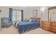 Bedroom with a comfortable blue patterned chair, a wooden dresser, and a big window creating an inviting space at 7523 Kimberly Lynn Ct, Lithonia, GA 30058