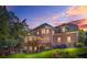 Back of brick home featuring a spacious outdoor deck and lush landscaping at sunset at 7523 Kimberly Lynn Ct, Lithonia, GA 30058
