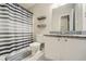 Updated bathroom features granite countertops, new fixtures, and a modern shower curtain with striped shelves at 840 Wells Se Cir, Smyrna, GA 30080