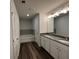 Bathroom boasts a granite countertop, dual sinks, and wood-look flooring at 115 Heyman Dr, Covington, GA 30016