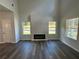 Bright living room with an electric fireplace and large windows, creating a cozy and inviting atmosphere with modern flooring at 115 Heyman Dr, Covington, GA 30016