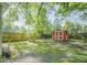 Serene backyard featuring a grassy area, a red outbuilding, and a wooden fence, perfect for outdoor enjoyment at 1311 Sylvan Cir, Brookhaven, GA 30319