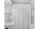 Compact bathroom featuring shower, toilet, and sink with white tile and shower curtain at 1311 Sylvan Cir, Brookhaven, GA 30319