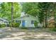 Charming single-story home with blue door, surrounded by mature trees and greenery at 1311 Sylvan Cir, Brookhaven, GA 30319