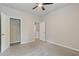 Neutral bedroom boasts carpet, ceiling fan, and closet to provide a cozy and functional space at 1537 Maplecliff Way, Sugar Hill, GA 30518