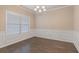 Elegant dining room featuring wainscoting, hardwood floors, and a chandelier for sophisticated dining at 1537 Maplecliff Way, Sugar Hill, GA 30518