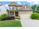 Charming two-story home featuring a two-car garage, inviting front porch, and well-manicured landscaping at 1537 Maplecliff Way, Sugar Hill, GA 30518