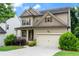 Inviting two-story home with a covered front porch, two-car garage, and well-maintained lawn and shrubbery at 1537 Maplecliff Way, Sugar Hill, GA 30518