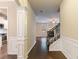 Hallway showcasing detailed trim, hardwood floors, and views of the living room and kitchen at 1537 Maplecliff Way, Sugar Hill, GA 30518