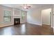Inviting living room with a cozy fireplace, hardwood floors, and abundant natural light from large windows at 1537 Maplecliff Way, Sugar Hill, GA 30518