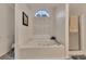 Bright bathroom with a large garden tub, shower and white shutters on an arched window at 1772 Brittany Chase Nw, Kennesaw, GA 30152