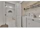 Bright laundry room with modern washer and dryer, shelving, and white tile flooring at 1772 Brittany Chase Nw, Kennesaw, GA 30152