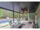 Covered patio with outdoor seating area, including a ceiling fan, overlooking the fenced backyard and pool area at 1772 Brittany Chase Nw, Kennesaw, GA 30152