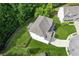 An aerial view of the backyard with a white house, green lawn, and wooded area at 1450 Rainfall Ct, Cumming, GA 30040