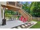 Backyard with a patio under the deck with table, chairs, and BBQ grill at 1450 Rainfall Ct, Cumming, GA 30040