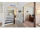 Inviting entryway with staircase, stylish rug, and an arched doorway leading to a bright, well-lit room at 1450 Rainfall Ct, Cumming, GA 30040