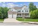 Beautiful two-story home with a brick and white exterior, well-manicured lawn, and an attached two-car garage at 1450 Rainfall Ct, Cumming, GA 30040