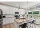 Modern kitchen with white cabinetry, stainless steel appliances, and a large island with a granite countertop at 1450 Rainfall Ct, Cumming, GA 30040
