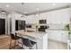 Modern kitchen featuring white cabinets, a granite island, and stainless steel appliances at 1450 Rainfall Ct, Cumming, GA 30040