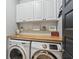 Cozy laundry room showcasing butcher block countertops, white cabinets, and modern Samsung washer-dryer at 1450 Rainfall Ct, Cumming, GA 30040