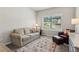 Comfortable living area with sofa, accent chair, ottoman and a large window at 1450 Rainfall Ct, Cumming, GA 30040