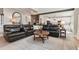 Spacious living room with a comfortable leather sectional sofa and an exposed brick wall at 1450 Rainfall Ct, Cumming, GA 30040