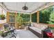 Relaxing screened porch with comfortable seating, ceiling fan, and view of lush greenery at 1450 Rainfall Ct, Cumming, GA 30040