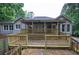 Backyard view featuring a tiered wooden deck surrounded by lush trees and a fenced perimeter at 23 Timberlake Pointe Ne, Cartersville, GA 30121