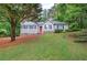 Charming single-story home features a manicured lawn, stone accents, and a welcoming red front door at 23 Timberlake Pointe Ne, Cartersville, GA 30121