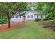 Charming single-story home features a manicured lawn, stone accents, and a welcoming red front door at 23 Timberlake Pointe Ne, Cartersville, GA 30121