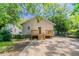 Backyard view featuring a small deck, back entrance, and a concrete driveway surrounded by lush greenery at 3361 Myrtle St, Atlanta, GA 30354
