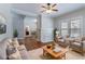 Virtually staged open living room with hardwood floors, brick fireplace, ceiling fan, and modern furniture at 3361 Myrtle St, Atlanta, GA 30354