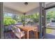 Virtually staged sunroom enclosed with many windows overlooking the outside, including dining furniture at 3361 Myrtle St, Atlanta, GA 30354