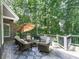 Relaxing outdoor living with a seating area and umbrella overlooking a lush wooded area at 5039 Towne Lake Hills North, Woodstock, GA 30189