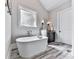 Luxurious bathroom with freestanding tub, elegant fixtures, and accent lighting at 5039 Towne Lake Hills North, Woodstock, GA 30189