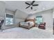 Bedroom boasts neutral walls, ceiling fan, large bed, and view-inviting windows at 5039 Towne Lake Hills North, Woodstock, GA 30189