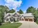 Stunning stone home with well-manicured lawn, three-car garage and impeccable curb appeal at 5039 Towne Lake Hills North, Woodstock, GA 30189