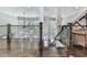 Open hallway showcasing dark wood floors, iron railing, and views to the lower level and surrounding windows at 5039 Towne Lake Hills North, Woodstock, GA 30189